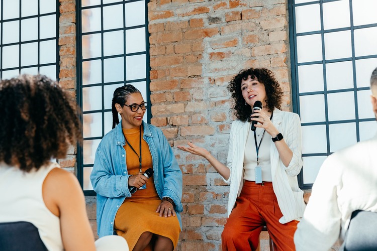 ppt-9484079595865-Women discussing leadership in a seminar at a modern office setting